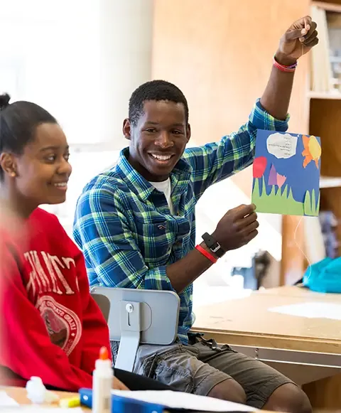 Student holding up an art project.